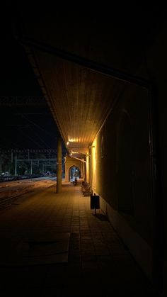 an empty walkway at night with lights on