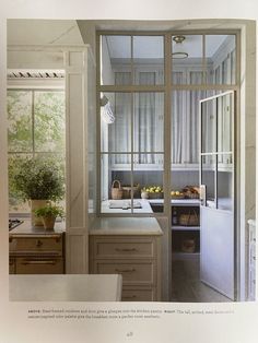 an open window in a kitchen next to a sink and counter top with a potted plant on it