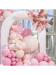 balloon arch with pink and white balloons on it