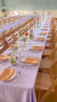 a long table is set up with place settings and flowers on it for an event