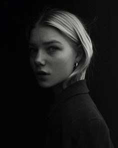 a black and white photo of a woman with blonde hair wearing a turtle neck sweater