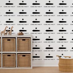 a wall with some black and white stars on it, next to a toy storage unit