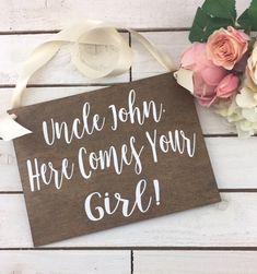 a wooden sign that says uncle john here comes your girl next to flowers and ribbon