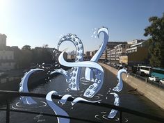 an octopus sculpture on the side of a bridge