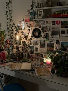 a desk with plants and pictures on the wall