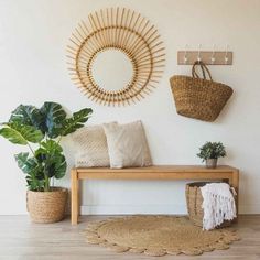 a wooden bench sitting next to a potted plant on top of a hard wood floor