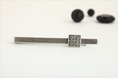 Everyone at the table will be so fixated on this stunning Sterling silver tie clip that he will be able to bluff the night away. The ideal gift for a poker player, the pendant on the clip is a beautiful square that features raised symbols of each of the four card suits. The black oxidization of the silver fills in the grooves and helps to give the symbols a 3D effect. The slightly rounded back allows the clip to easily slide over your tie. Comes in a handsome black alligator print gift box. FREE Silver Adjustable Suit And Tie Accessories For Gift, Luxury Silver Lapel Pin As Gift, Personalized Tie Clip, Silver Money Clip, Silver Clip-on Cufflinks For Gift, Alligator Print, Tie Bar Clip, Silver Tie, Bar Items