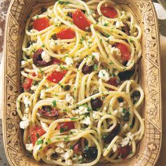 pasta with tomatoes, olives and fettuccine in a dish on a table