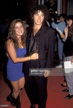 an image of a man and woman posing for the camera in front of other people