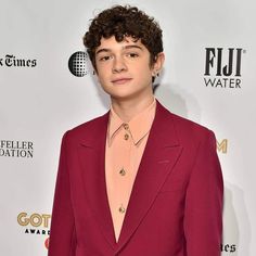 a young man in a red suit and pink shirt at the film awards gala event