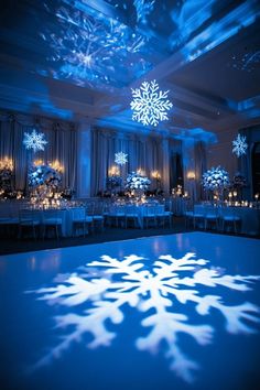 a snowflake is projected on the dance floor in front of an elegant banquet room