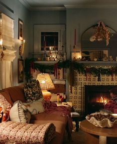 a living room filled with furniture and a fire place in front of a christmas tree