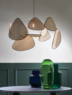 a group of vases sitting on top of a table next to each other in front of a white wall