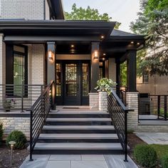 a black and white house with stairs leading up to the front door