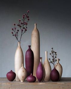 a group of vases sitting on top of a wooden table