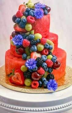 a three tiered cake with fruit on top