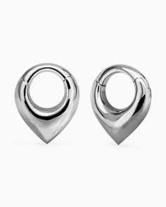 two pairs of silver earrings on a white background, one is shaped like a heart