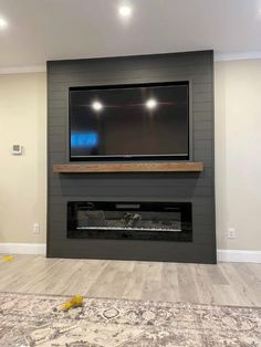 a flat screen tv mounted on the wall above a fireplace