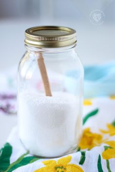 a glass jar filled with white sand on top of a table