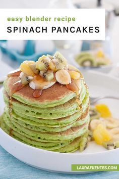 a stack of pancakes with bananas and kiwis on top, sitting on a white plate