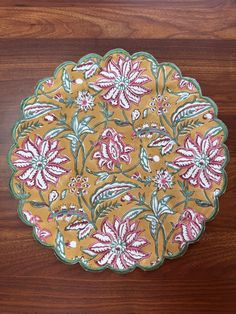 a brown and pink flowered plate on a wooden table with wood grain flooring