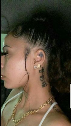 a woman with tattoos on her neck sitting in a car