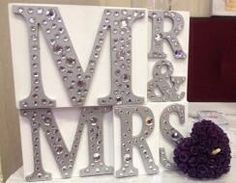 a couple of letters sitting on top of a table next to a purple pom pom