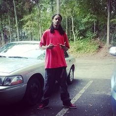 a man standing in front of a parked car