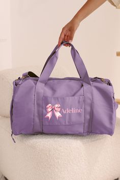 Elevate your everyday style with our Personalized Name Duffel Bag, a versatile accessory that seamlessly blends fashion and functionality. This 9-inch tall, 18.5-inch long, and 10.5-inch wide bag is designed to add a touch of sophistication to your daily outings. What sets our duffle bag apart is its unique design. The compartments are separated from each other with zippers from both the top and the side of the bag. A variety of color choices with many different font options are available for yo Sporty Travel Bag For School, Rectangular Purple Duffle Bag For Everyday Use, Sporty Purple Shoulder Bag For Travel, Purple Rectangular Duffle Bag For Daily Use, Purple Large Capacity Gym Bag For Daily Use, Purple Large Capacity Gym Bag, Functional School Duffle Bag With Removable Pouch, Functional Duffle Bag With Removable Pouch For School, Purple Duffle Bag For Daily Use