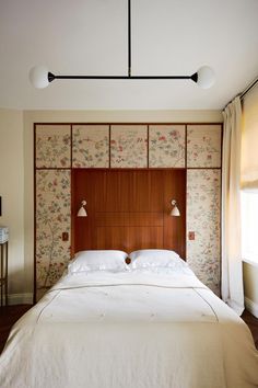 a bed with two lamps on either side of it and a headboard made out of wood