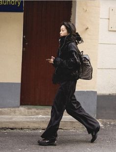 a woman walking down the street with a handbag