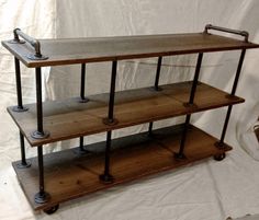 three tiered wooden shelf with metal handles and wheels on each side, against a white backdrop