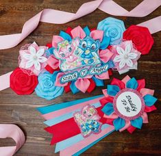 some paper flowers and ribbons on a wooden table with the name stitch o'angel