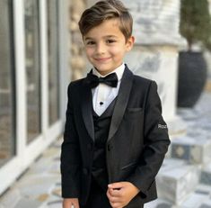 a young boy in a tuxedo and bow tie