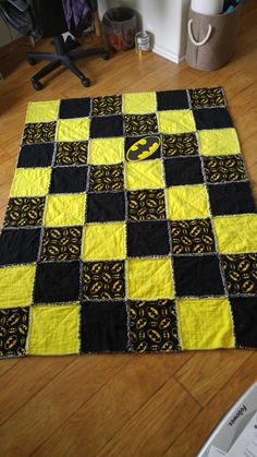 a black and yellow patchwork rug on the floor