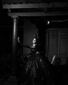 a black and white photo of a woman in a long dress with sequins