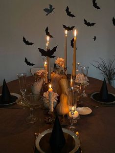 a dining room table with candles and bats on the wall in the backround