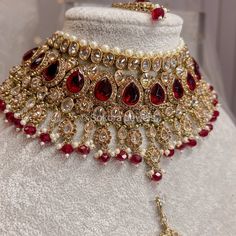 Antique Gold set made up of champagne zircon crystals and maroon beads.  Comes complete with matching slim tikka:  1.5 inch pendant with 4 inch chain, 2.5 inch jhumka earrings and jhumar is optional Ready to ship as seen with gift box. Jewellery Sets Indian, Antique Gold Set, Bridal Jewelry Sets Indian, Pakistani Wedding Jewelry, Pakistani Necklace, Pakistani Bridal Jewelry, Bridal Choker, Silver Necklace Set, Bridal Necklace Set