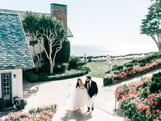 a bride and groom walking down the path to their wedding ceremony at an oceanfront resort