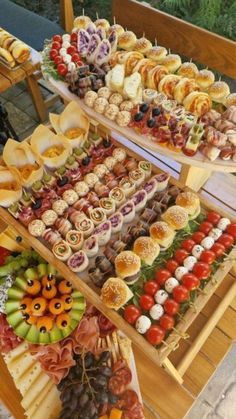 an assortment of food on display at a buffet or wedding reception in the garden, including finger foods and appetizers