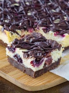 a close up of a piece of cake on a cutting board with chocolate drizzled over it