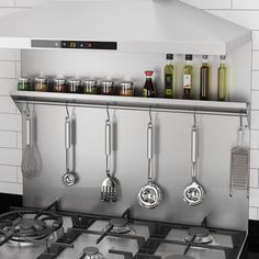 a stove top with pots and pans hanging on the wall