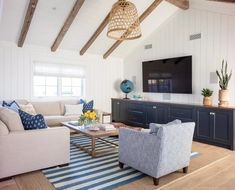 a living room filled with furniture and a flat screen tv mounted to the side of a wall