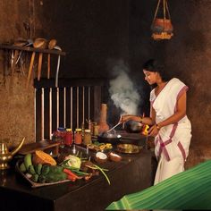 a woman cooking food in a small kitchen