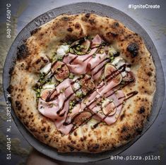 a pizza sitting on top of a metal pan covered in toppings next to a person's hand