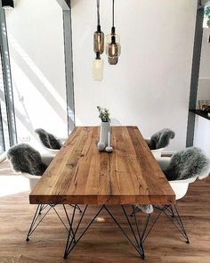 a wooden table with white chairs in a room