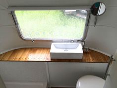 a bathroom with a sink, toilet and window in the back ground is seen from above