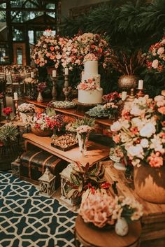 a table topped with lots of flowers and cakes