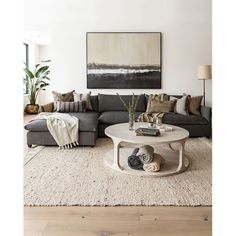 a living room filled with furniture and a large painting on the wall above the couch