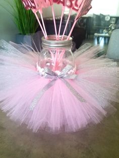 a mason jar filled with pink and silver candy sticks